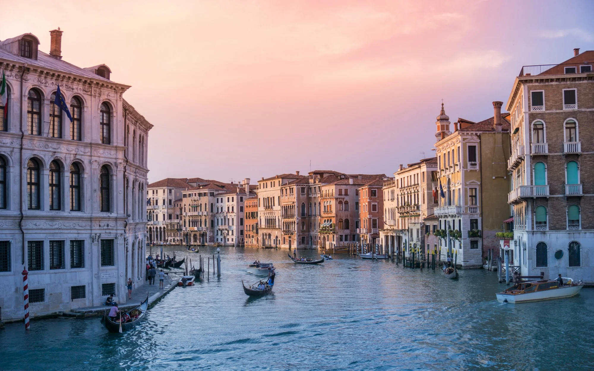 Gondolas on a canal between buildings in Venice, Italy