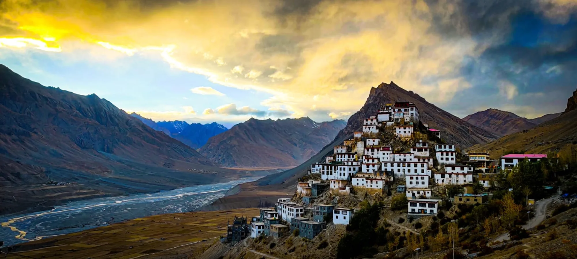 A village on a hillside beside a river in the Spiti Valley, Himachal Pradesh