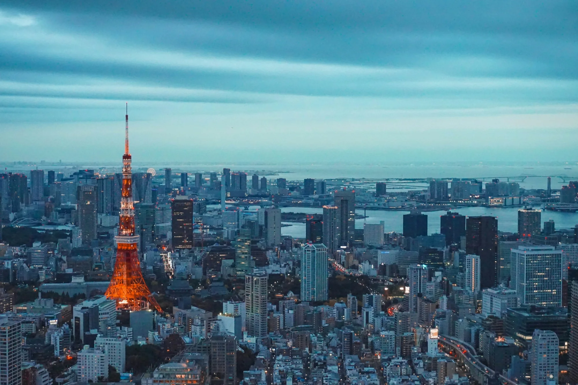 Tokyo Tower illuminated at dusk above the city skyline