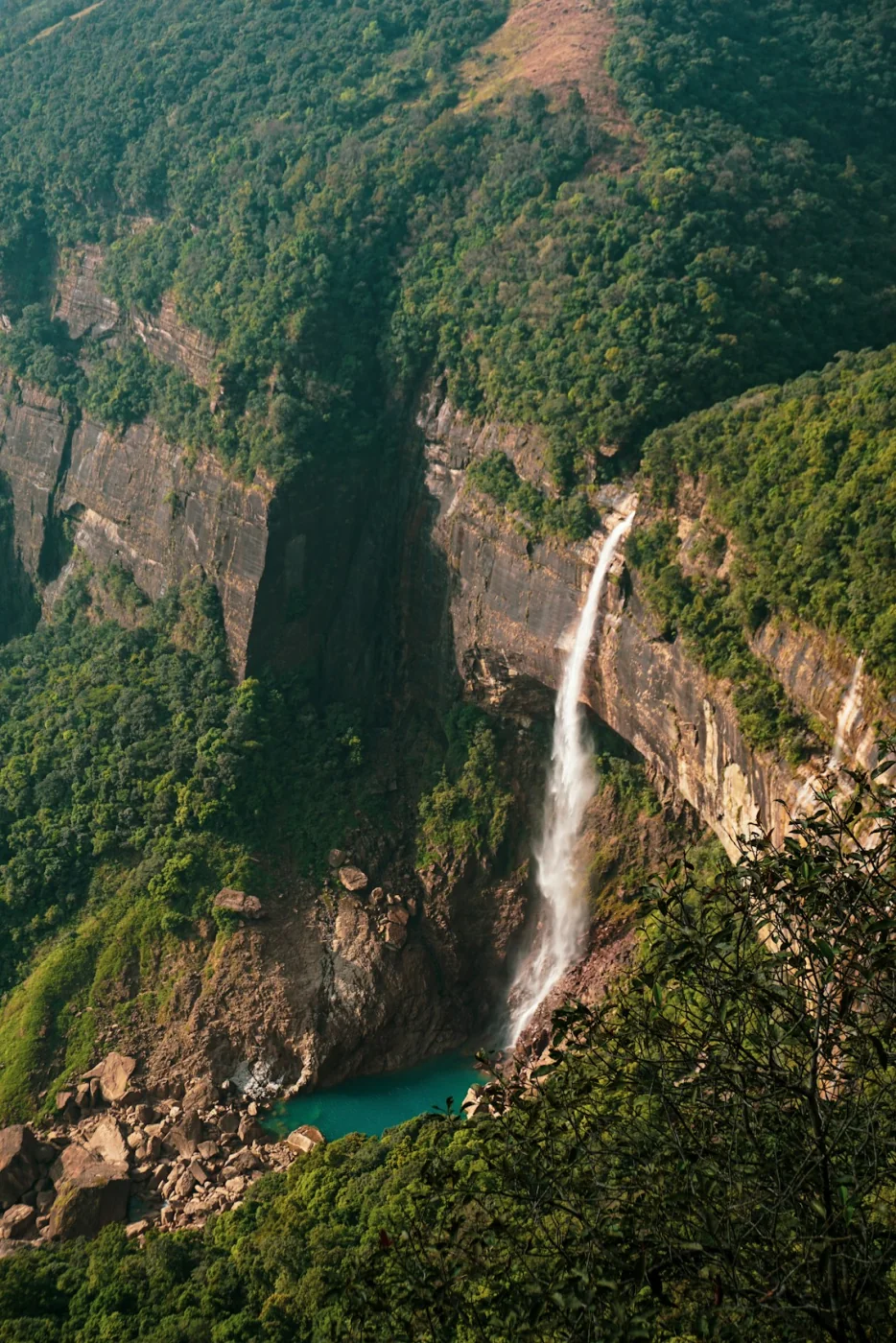 A waterfall in a lush green valley in Meghalaya