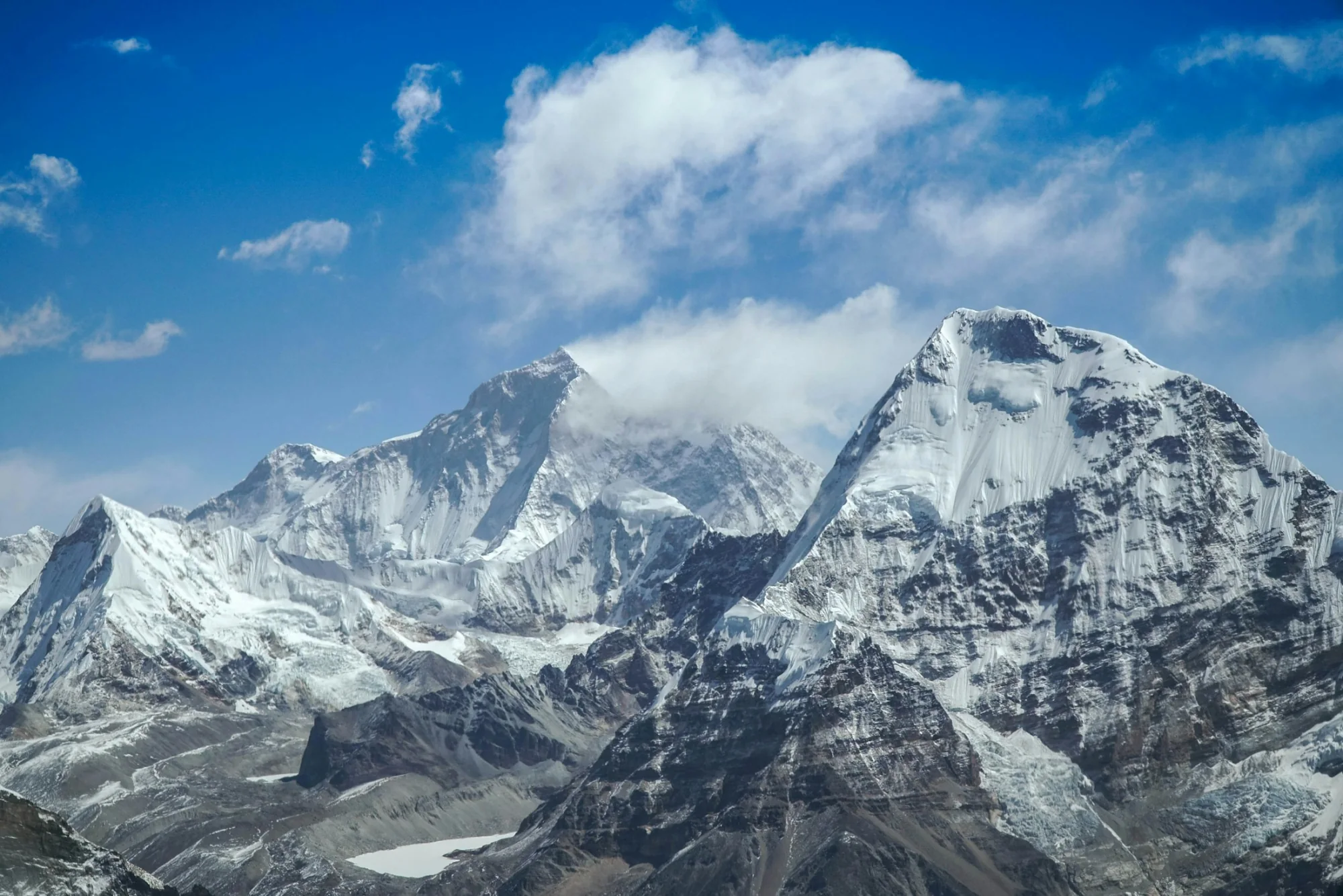 A snow-covered Himalayan summit under blue skies in Nepal