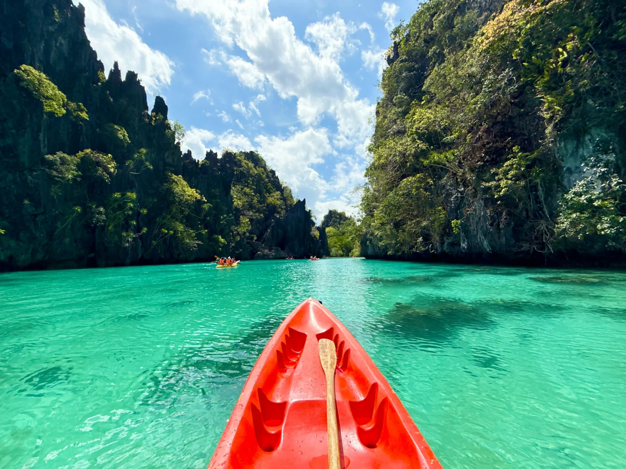 Kayaking through a turquoise lagoon among limestone cliffs at El Nido, Palawan