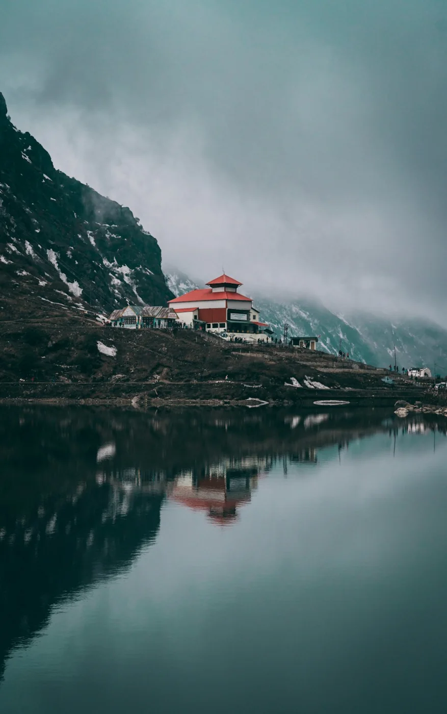 A red-and-white Buddhist monastery beside the water in Sikkim