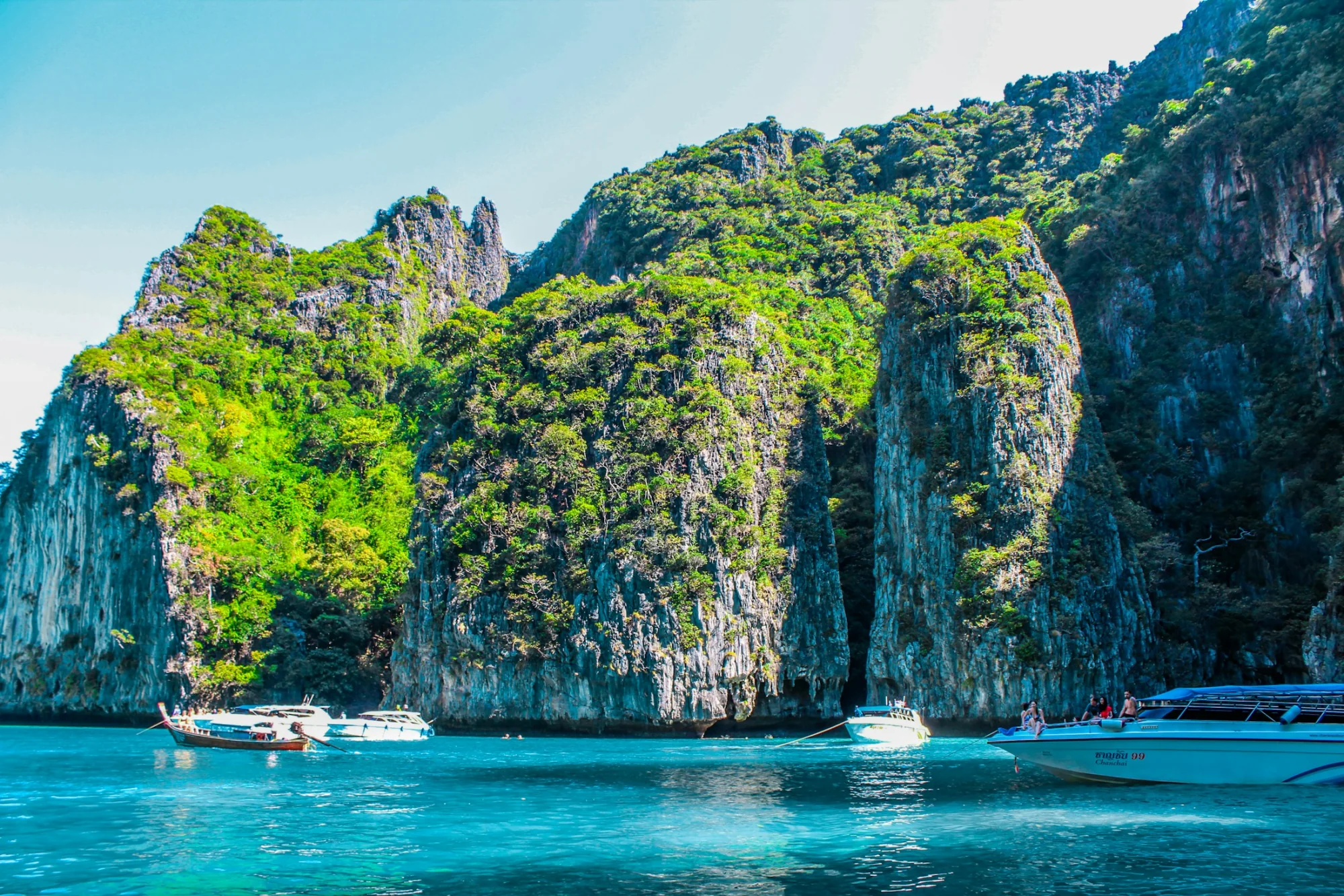 A boat beneath the limestone karsts of Krabi, Thailand